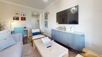 A living room with a blue couch and a white coffee table.